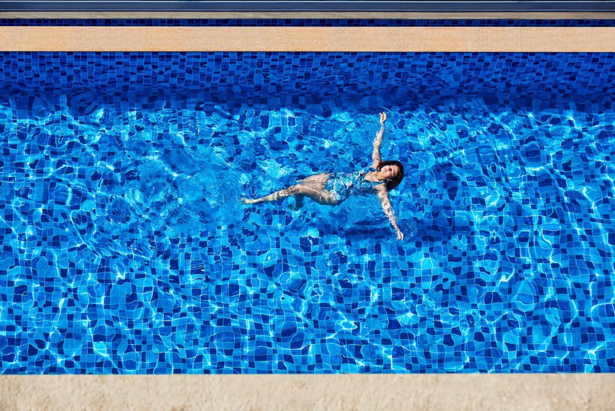 Novotel Mumbai International Airport ภายนอก รูปภาพ A woman floating in a swimming pool